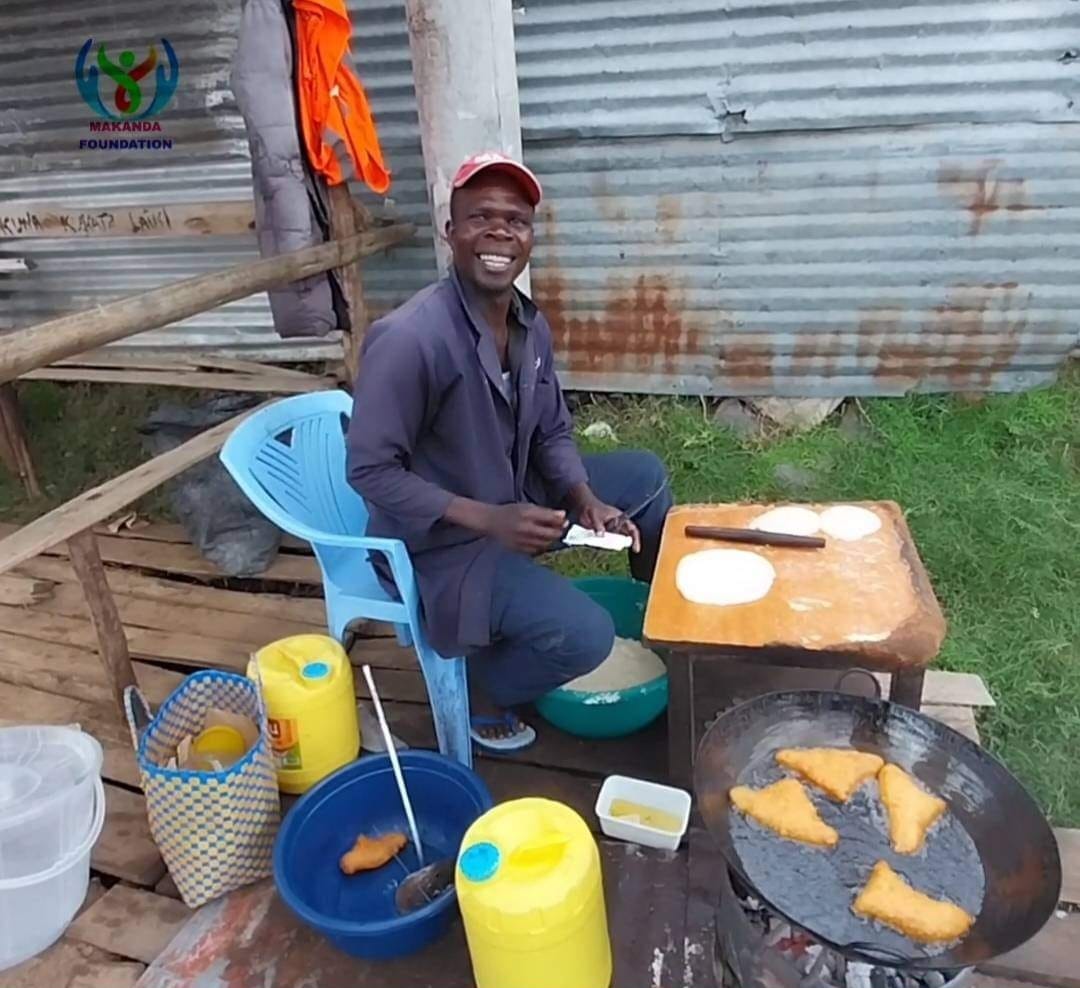 A man making mandazi in an open place.